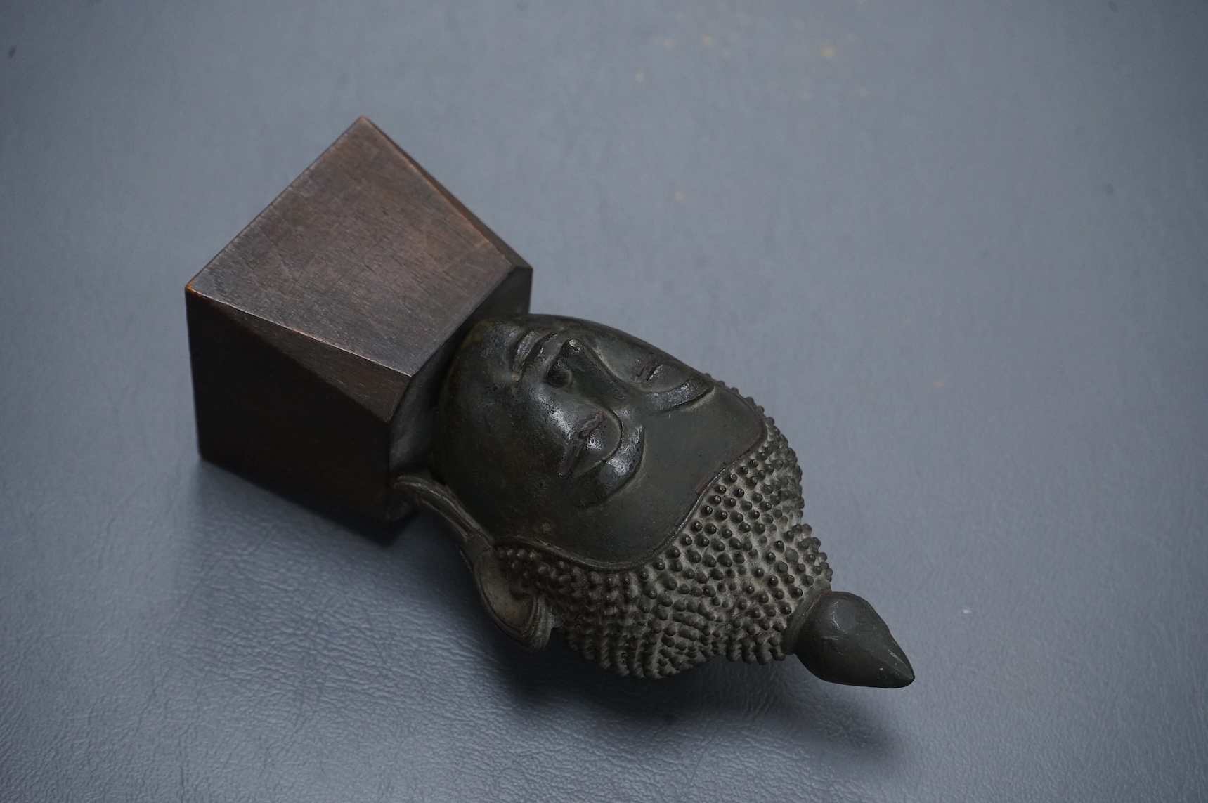 A 17th/18th century Thai, Ayuthia style, bronze head on wooden stand - 14cm high including stand.